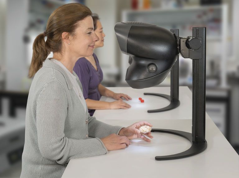 OPTA stereo microscope used by two women technicians
